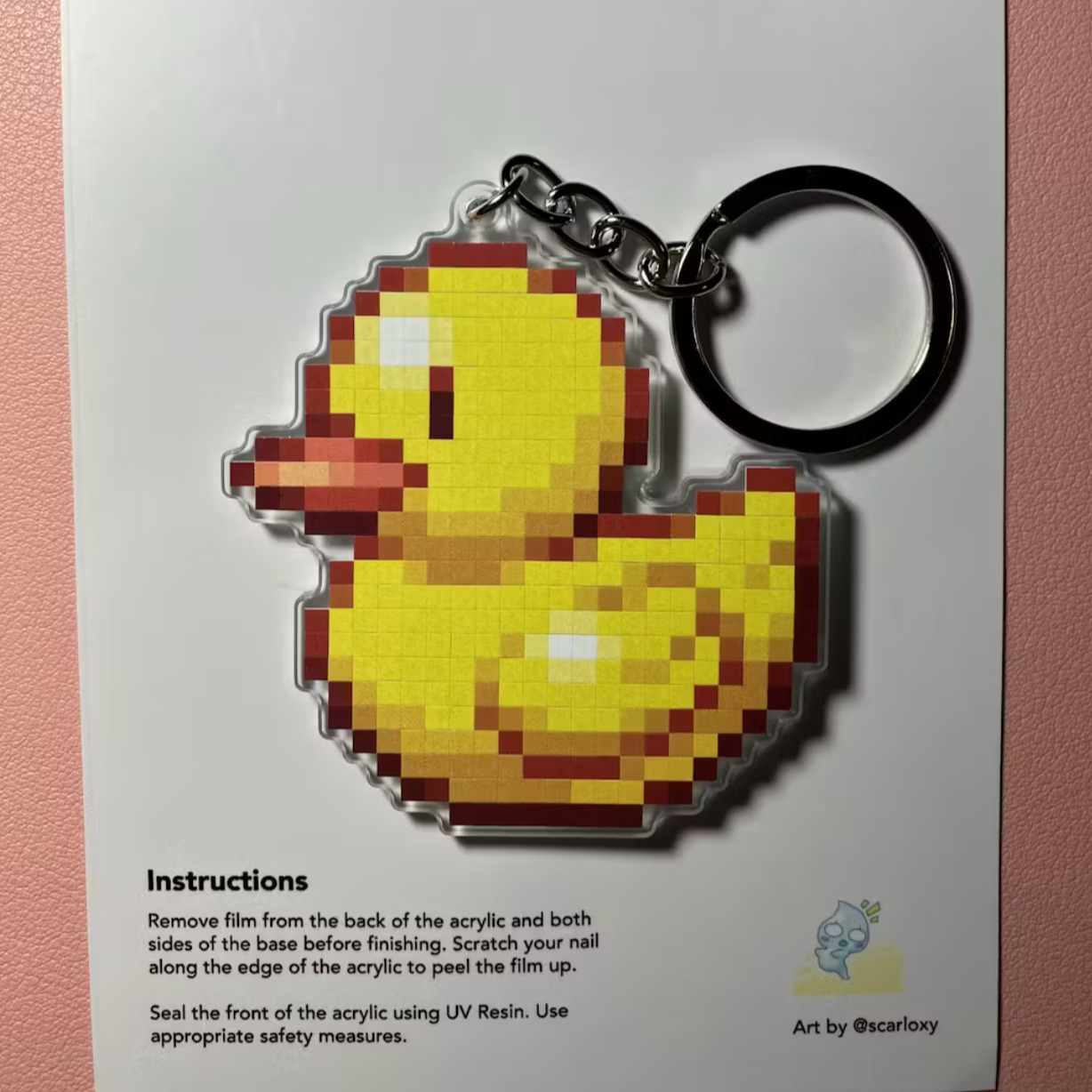 Pixelated duck keychain on a Pixyls branded card with instructions.